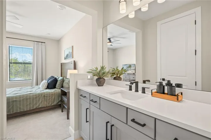 Ensuite bathroom featuring a ceiling fan, vanity, and ensuite bath