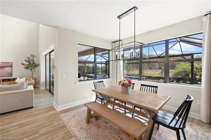 Dining area with baseboards, light wood-style flooring, and plenty of natural light