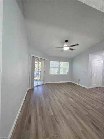 Spare room with wood finished floors, healthy amount of natural light, and ceiling fan