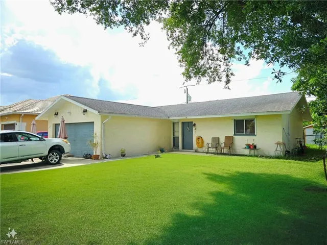 Single story home featuring a garage and a front lawn