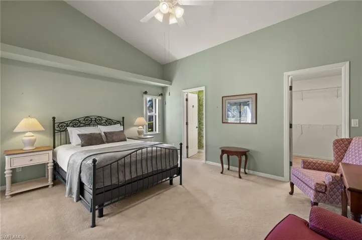 Bedroom featuring a closet, light colored carpet, ceiling fan, a spacious closet, and high vaulted ceiling