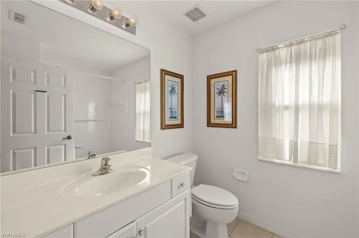 Bathroom featuring toilet, tile patterned floors, and vanity