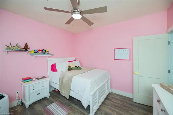 Bedroom with ceiling fan and dark wood-style flooring