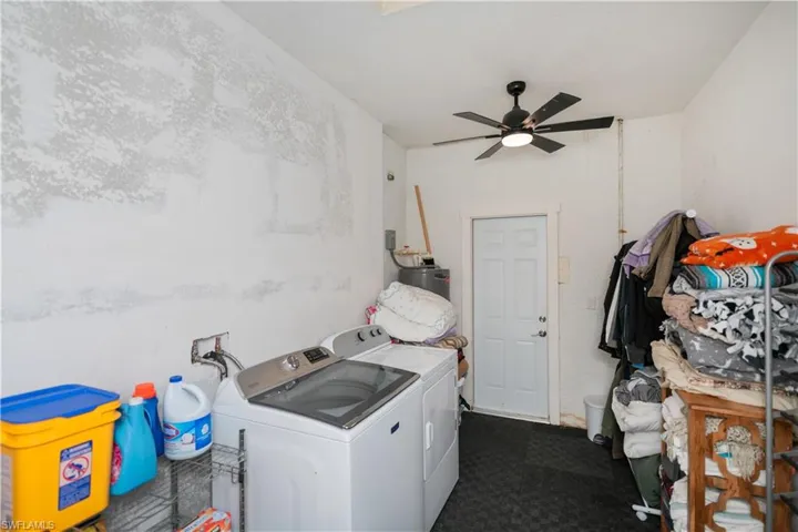 Laundry area with washer and dryer, ceiling fan, and water heater