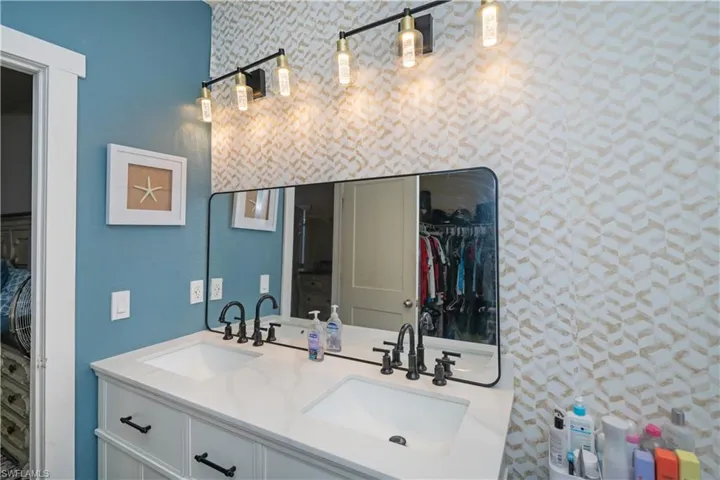 Full bathroom featuring double vanity and a walk in closet