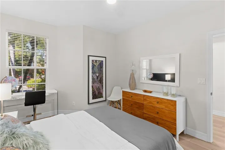 Bedroom with multiple windows, light wood-style floors, and ceiling fan
