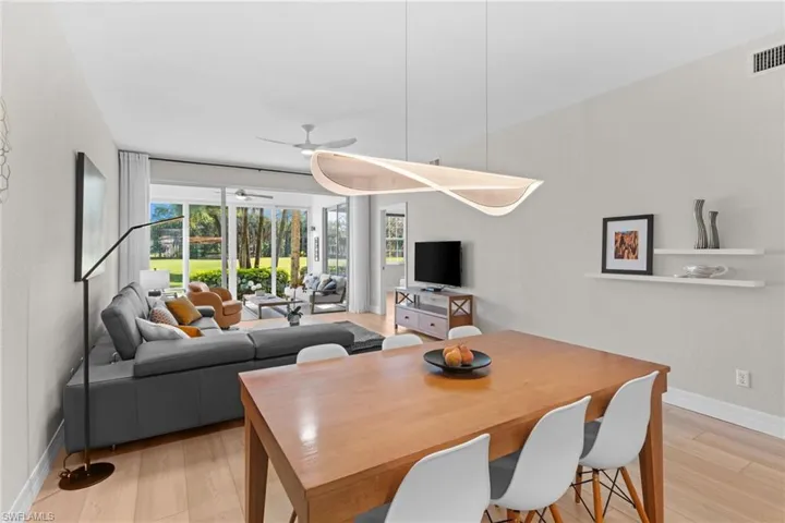 Dining space with light wood-style flooring and ceiling fan