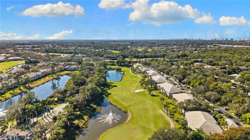 Aerial perspective of suburban area with a nearby body of water and a golf club