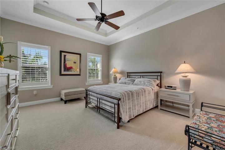 Guest room with tray ceilings and plantation shutters.
