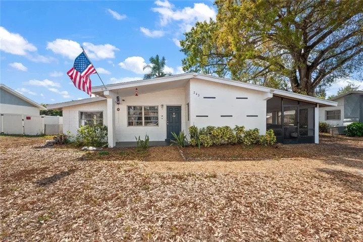 View of front of property featuring a sunroom and concrete block siding