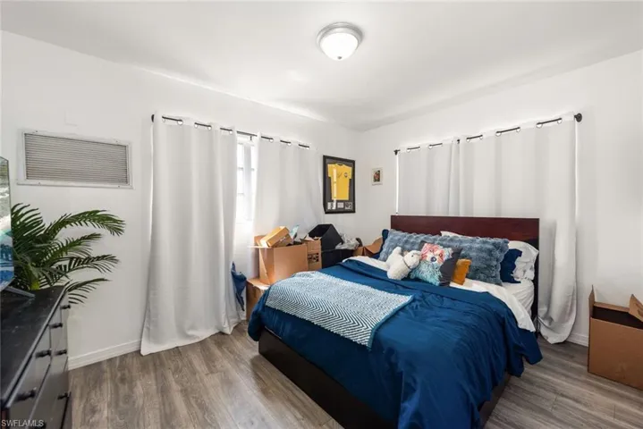 Bedroom featuring dark wood-style floors and baseboards