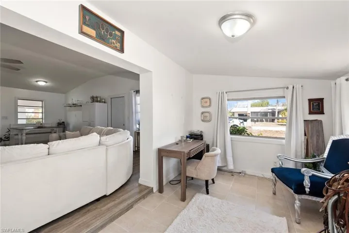Living area featuring lofted ceiling and light tile patterned flooring