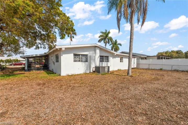 Rear view of house featuring stucco siding and a sunroom