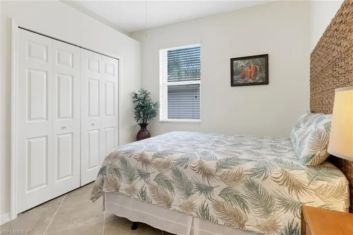 Tiled bedroom featuring a closet