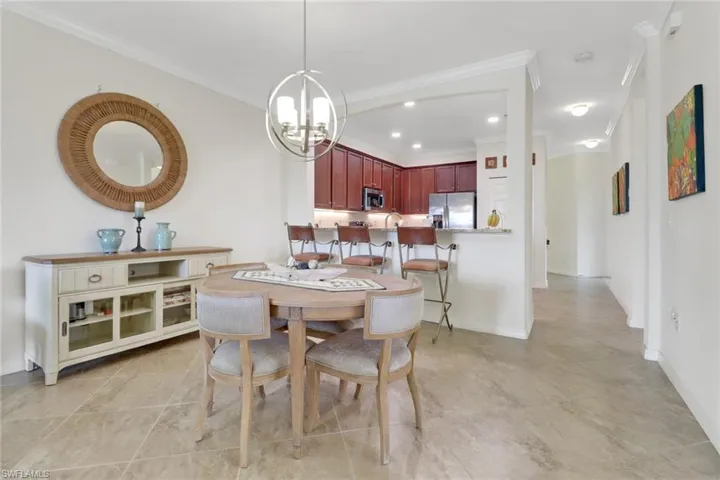 Dining area with crown molding and a notable chandelier