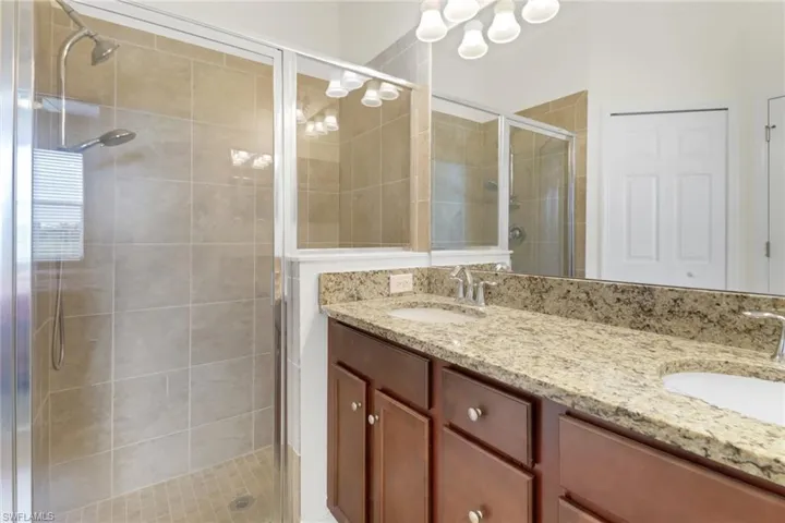 Bathroom featuring a shower with door and vanity