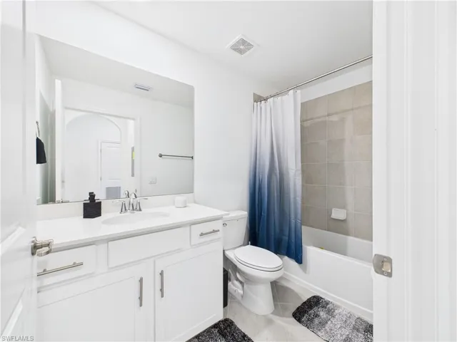 Full bathroom with tile patterned floors, vanity, and shower / tub combo