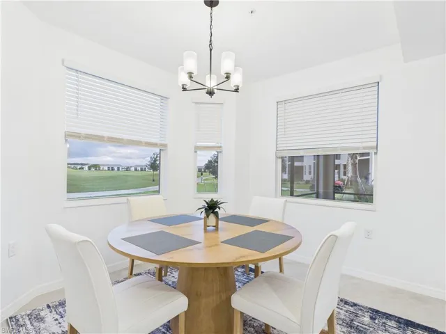 Dining room featuring baseboards and a chandelier