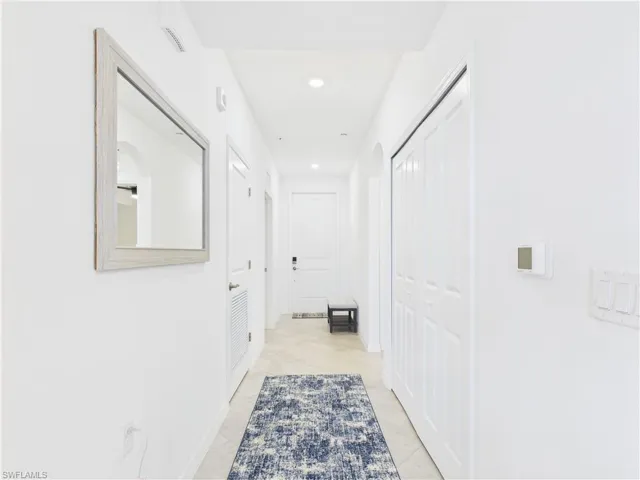 Hallway with recessed lighting and light tile patterned floors