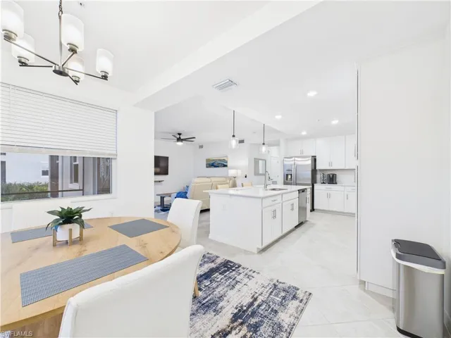 Dining space featuring a ceiling fan, light tile patterned flooring, recessed lighting, and a chandelier