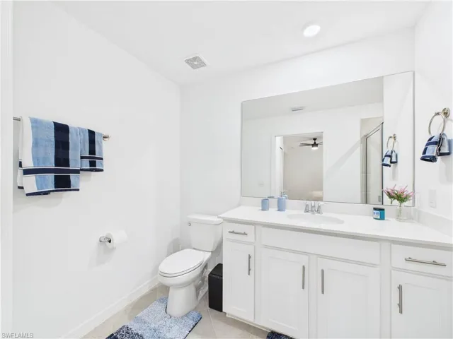 Bathroom with vanity, tile patterned flooring, a shower with door, and a ceiling fan