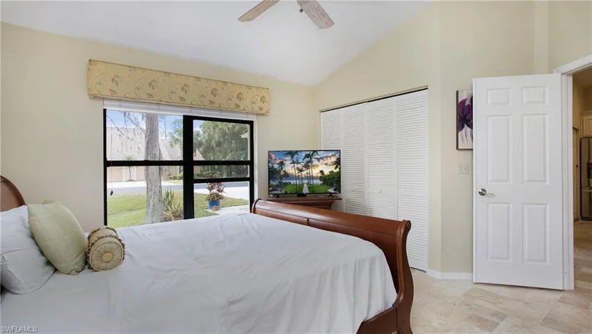 Bedroom with vaulted ceiling, ceiling fan, and a closet