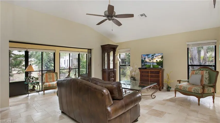 Living room with ceiling fan and lofted ceiling