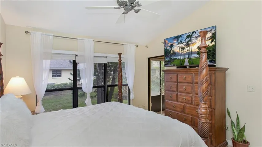 Bedroom with ceiling fan, vaulted ceiling, and multiple windows