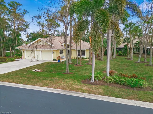 View of front of home with a front yard and a garage