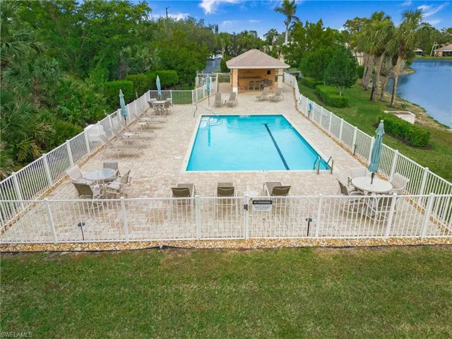 View of pool with a patio area, a water view, and a yard