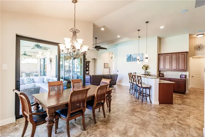 Dining area adjacent to kitchen with lofted ceiling and a chandelier