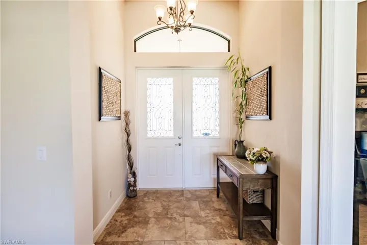 Entrance foyer featuring french doors and chandelier