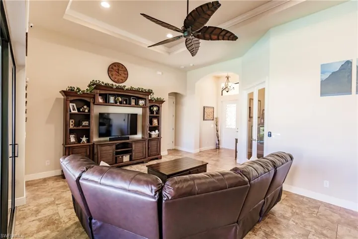 Living room featuring ceiling fan and a tray ceiling