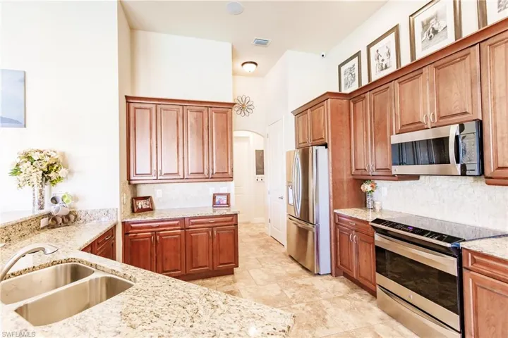 Kitchen featuring stainless steel appliances, tasteful backsplash, and light granite countertops.