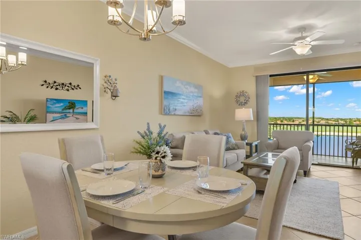 Dining area featuring a chandelier, tile patterned flooring, crown molding, and a ceiling fan