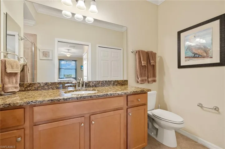 Full bath featuring toilet, a shower stall, vanity, tile patterned floors, and baseboards