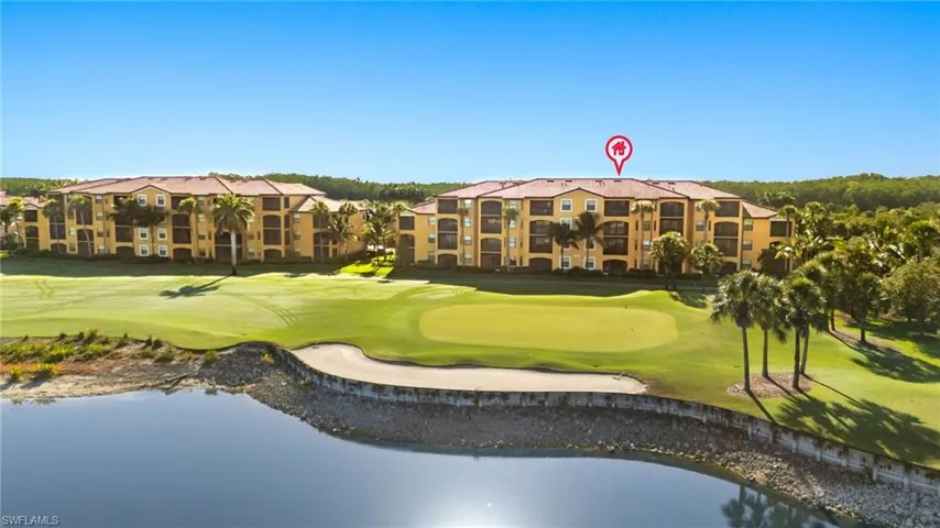 View of property's community with an area to practice putting, golf course view, and a water view