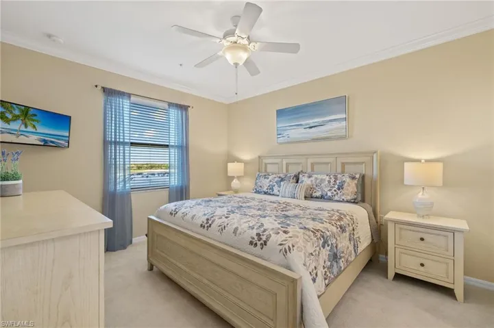 Bedroom featuring light colored carpet, ornamental molding, baseboards, and ceiling fan