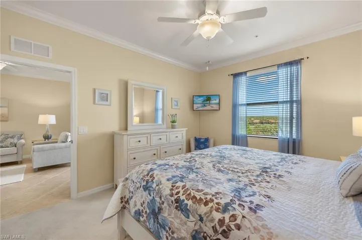 Bedroom with crown molding, light carpet, baseboards, and ceiling fan