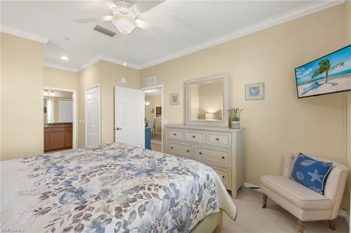 Bedroom with ornamental molding, light carpet, ensuite bathroom, recessed lighting, and a ceiling fan