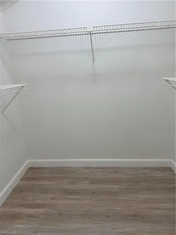 Walk in closet with light wood-style floors