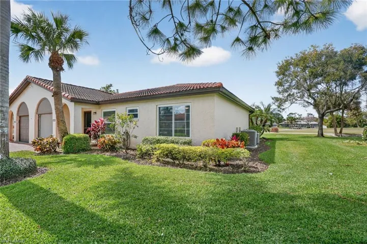 View of property exterior featuring a garage, stucco siding, a lawn, and a tiled roof
