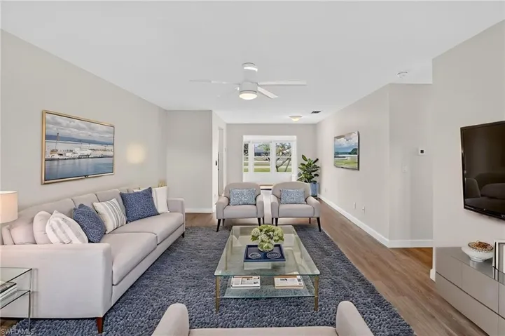 Living area with light wood finished floors and ceiling fan