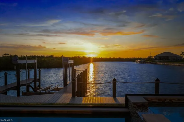 Boat dock and lift with a sunset water view