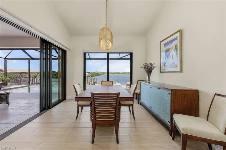 Dining room with access to lanai and pool, tile flooring, and chandelier light fixture