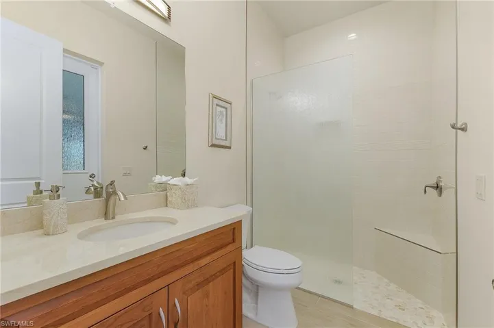 Bathroom/Pool bath featuring tile flooring, tile shower, and vanity