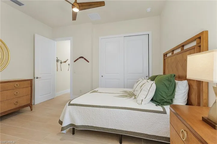 Bedroom with tile flooring, ceiling fan, and en-suite bathroom