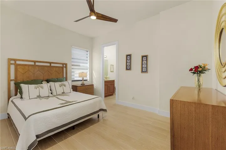 Bedroom with tile floors, ceiling fan, and en-suite bathroom