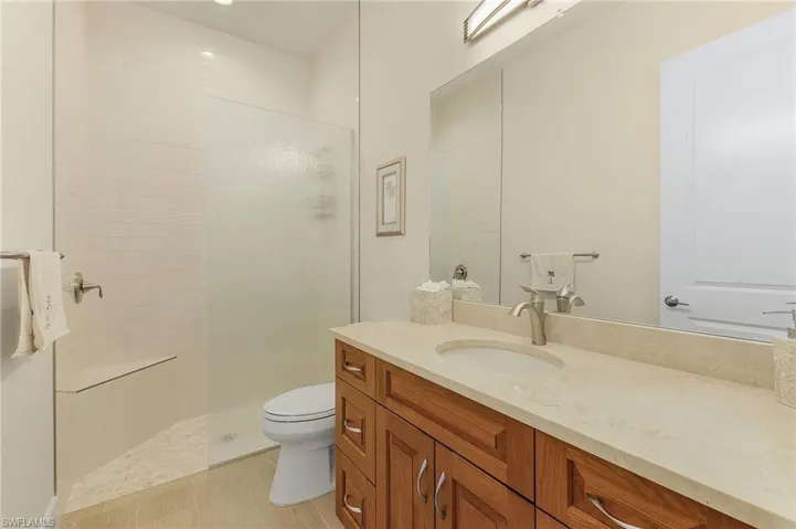 Bathroom featuring tile floor, tile shower, and vanity