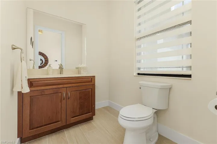 Half Bathroom with tile flooring, and vanity